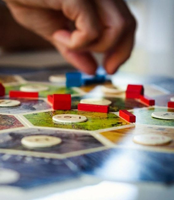 Main plaçant un pion sur un plateau de jeu de société